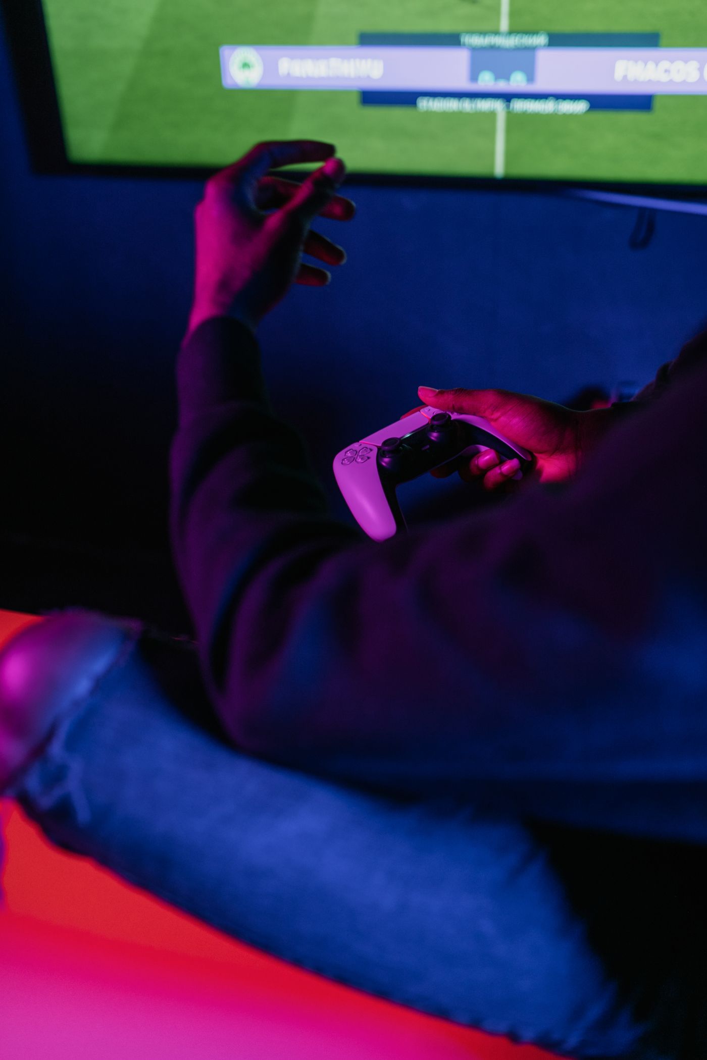 Player holding a controller under neon light
